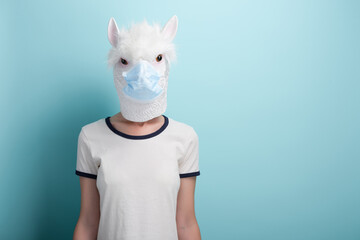 Young woman wearing alpaca and medical protection mask, isolated on blue background.