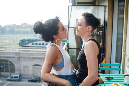Smiling lesbian women talking in balcony