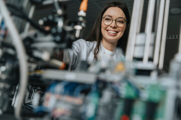 Close-up of smiling female scientist examining machinery in laboratory at factory