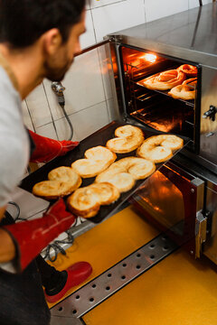 Baker baking on sheet at bakery