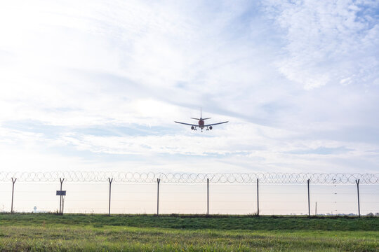 Airplane preparing to land over wire fence