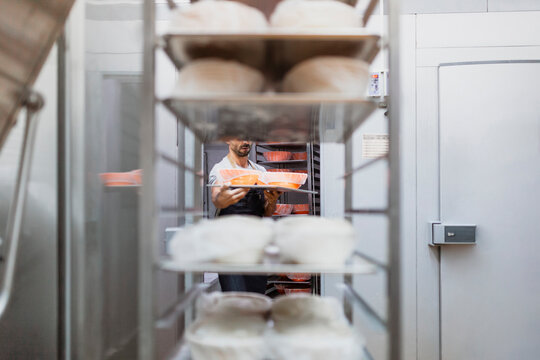 Baker working in commercial kitchen at bakery