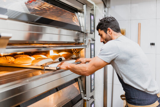 Baker baking bread at bakery