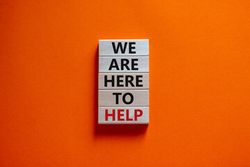 Wooden blocks with text 'we are here to help'. Beautiful orange background, copy space. Business concept.