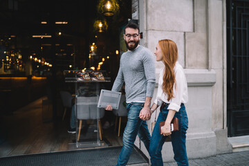 Cheerful couple walking and talking on street