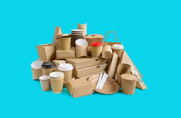 Many Various take-out food containers, pizza box, coffee cups in holder and paper boxes on aqua blue background.