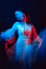 blurry portrait of a young girl with mental disorders in a dress on a dark background