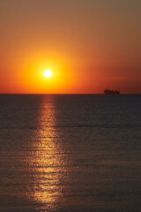Naklejka na ściany i meble Sunset on the sea, ships standing on the horizon.