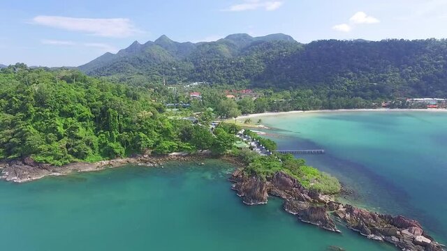 Tropical Koh Chang island dense mountain woodland idyllic turquoise bay coastline aerial view descending