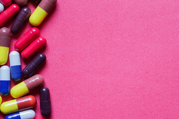 heap of capsules in pink background with space for text