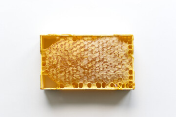 Fresh honey in a mini frame stands on a white background. Reserve vitamins for the winter