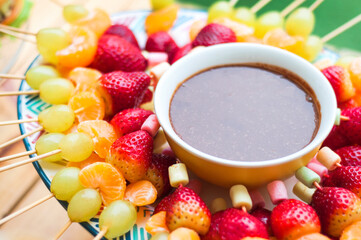 Fresas uvas y mandarinas listas para comer junto a chocolate.