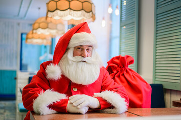 Friendly santa claus in a cafe.