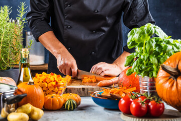 cropped shot of chef chopping ingredients for pumpkin soup