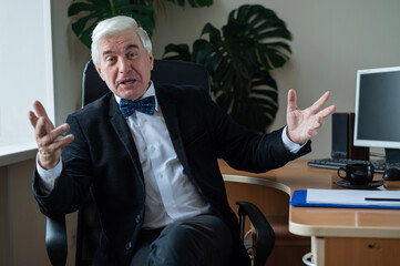 Charming mature gray-haired man at his desk.