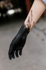 Girl's hand in black colour on the grey background 