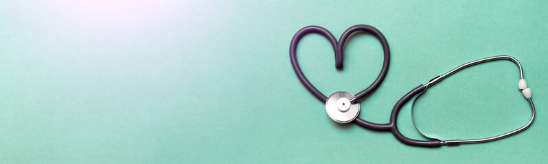 Stethoscope in Shape of Heart Isolated On Green Background. Banner. Copy space. Place for text.