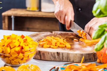 cropped shot of chef chopping ingredients for pumpkin soup