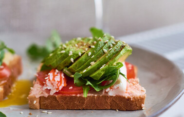 Healthy and beautiful breakfast of boiled eggs benedict, fresh vegetables of avocado, tomatoes and figs, watermelon on toast with black and strong coffee.