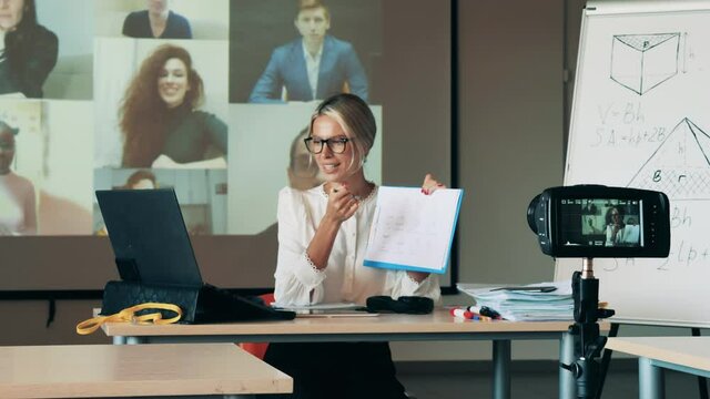 A teacher is talking to adult students during an online lesson. Distant studying, remote education, online lesson during lockdown.