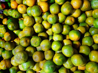 heap of ripe green yellow sweet lemon mosambi lebu for sale in fruit market