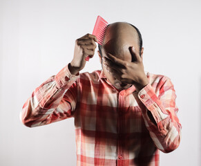 bald man covering his face in shame in white background with space for text