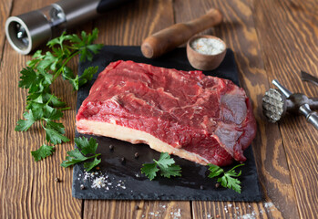 Raw beef fillet on wooden boards, parsley, meat tenderizer hammer and salt with spices