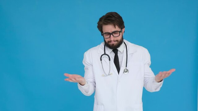 Portrait Of Unsure Doctor In Professional Medical White Coat Shrugs His Arms, Makes Gesture Of I Don't Know, Care. Body Language. Doc Man