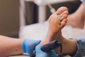 Process pedicure close-up, polishing feet, unrecognizable people. blurred face.