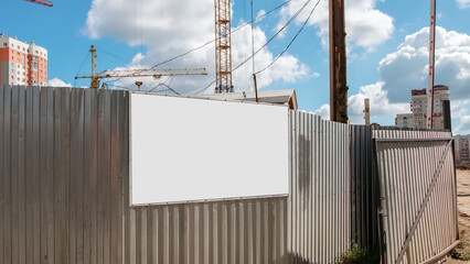 information board with white blank mockup on metal fence of construction site