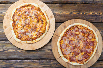 cutting boards with hot testy pizzas on wooden background,top view 
