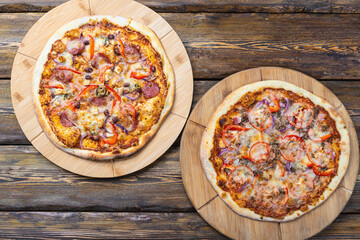 cutting boards with hot testy pizzas on wooden background,top view 