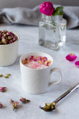 Pink moon milk with rose petals, healthy ayurvedic drink in mug