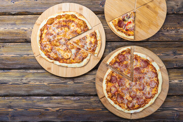 cutting boards with hot testy pizzas on wooden background,top view 