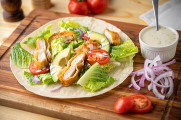 crispy chicken wrap on wooden board