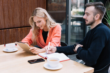 Focused colleagues working in cafe together