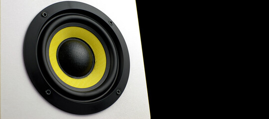 White audio speaker, isolate on a black background. Subwoofer, close-up. Minimalistic audio speaker with yellow subwoofer, copy space. Stereo music audio