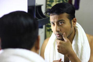 man looking after his appearance in front of a mirror beauty styling lifestyleindian asian man...