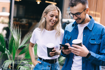 Happy couple with coffee cups on street