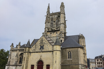 Fototapeta premium Built in heart of Fecamp XVI century Saint-Etienne church dominates now wearing Norman city: Renaissance portal, flamboyant Gothic steeple. Fecamp, Seine-Maritime department, Haute-Normandie, France.