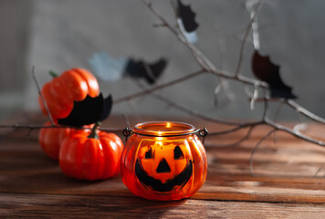 Halloween pumpkins on the wooden table with black wall and garland yellow lights