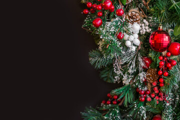 Christmas fir twig with red berries on dark background