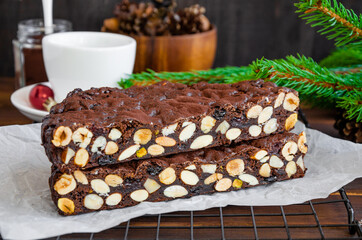Panforte. Traditional Italian Christmas dessert with nuts and dried fruit on a dark wooden background. Horizontal, copy space.