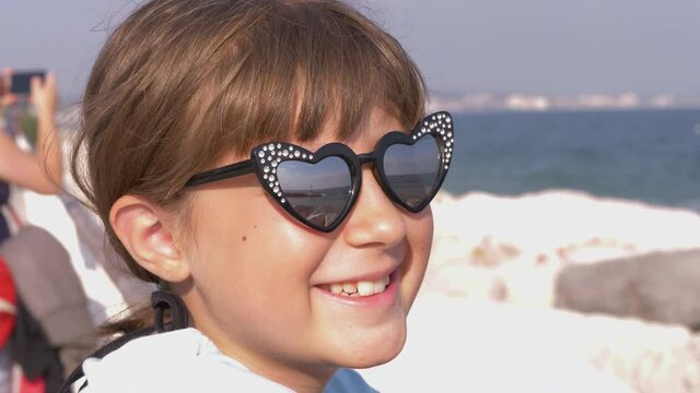 young girl at the sea with sunglasses with reflection on the landscape