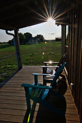 adirondack chairs sitting on sunny porch of cabin rental in wine country texas with sun star and...
