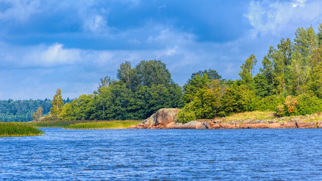 Picturesque rocky shore of the island with huge multi-ton boulders (erratic blocks). Baltic fundamental crystalline formations and glacial landscape (drift epoch) in Gulf of Finland Skerries.