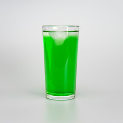 glass of green juice with ice on a white background