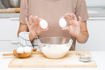 young woman making dough. on the table: flour, eggs, salt