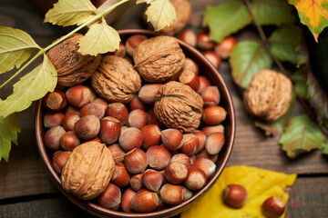 autumn still life in rustic style as a background - leaves, vegetables and fruits, nuts and other natural food ingredients on wooden boards