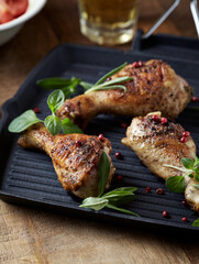 Spicy chicken drumsticks with fresh herbs. Close up. 